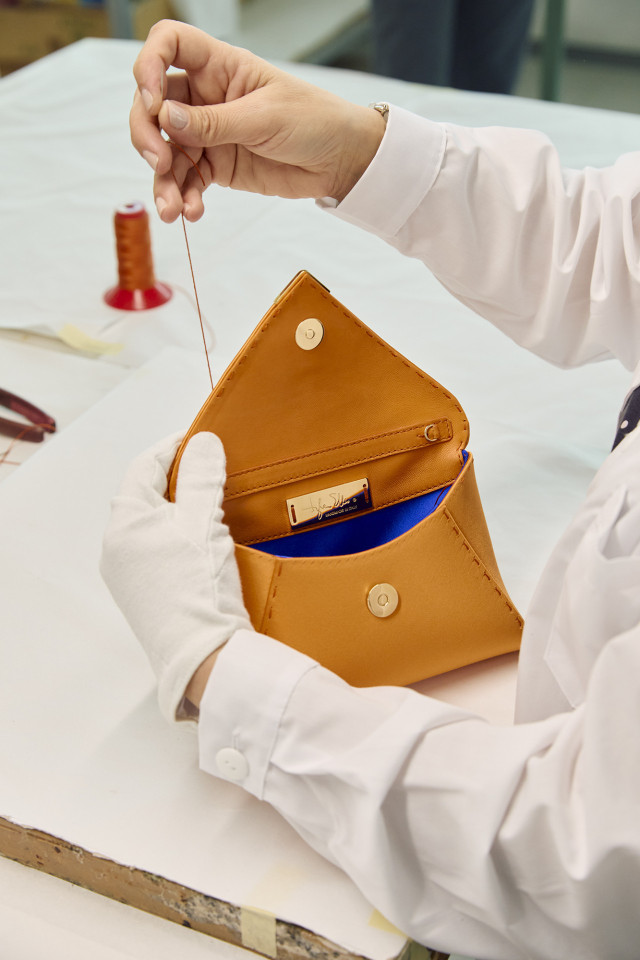 person making leather handbag in atelier 