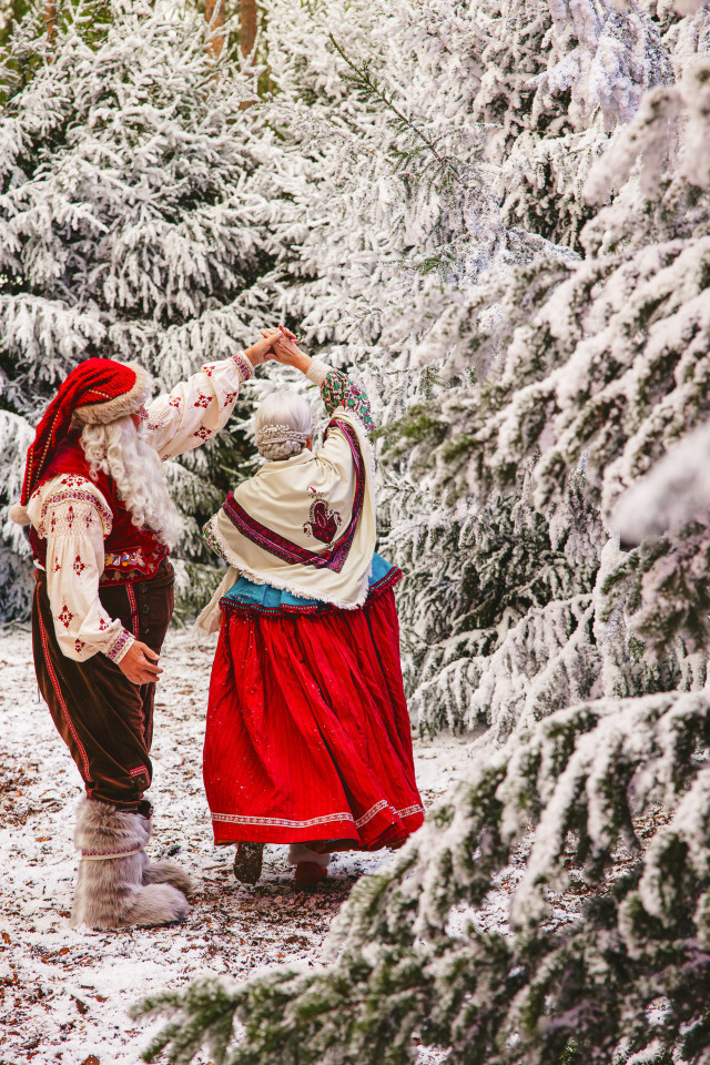 mother and father christmas dancing by snow-capped trees