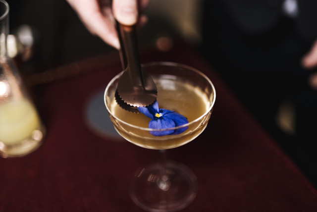 pansy flower being placed on cocktail 