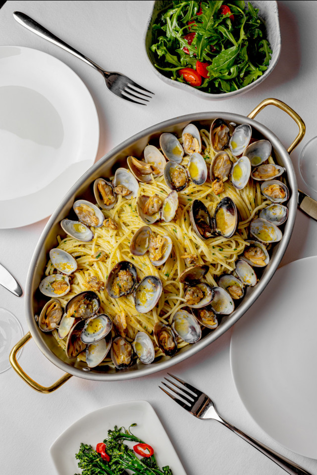 dish of linguine with clams and green vegetables