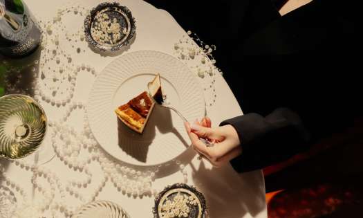 Photo of woman eating dessert at restaurant table with pearls .