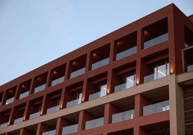 Red hotel exterior with external lights.