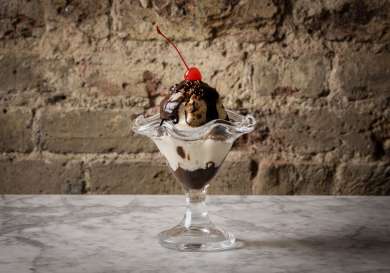 Sundae dessert with a glace cherry on top .