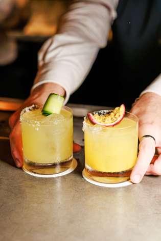 Bartender with two spicy margaritas.