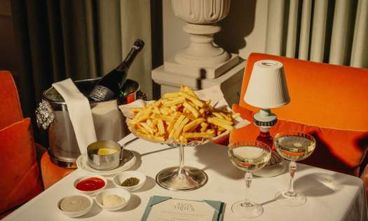 Photo of table topped with plate of chips and two glasses of champagne.