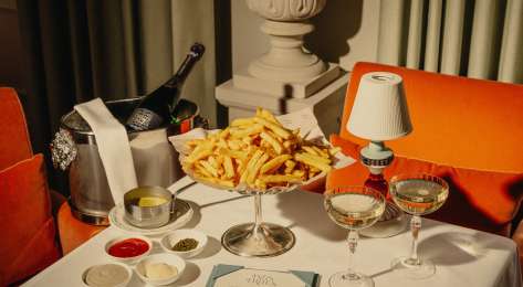 Photo of table topped with plate of chips and two glasses of champagne.
