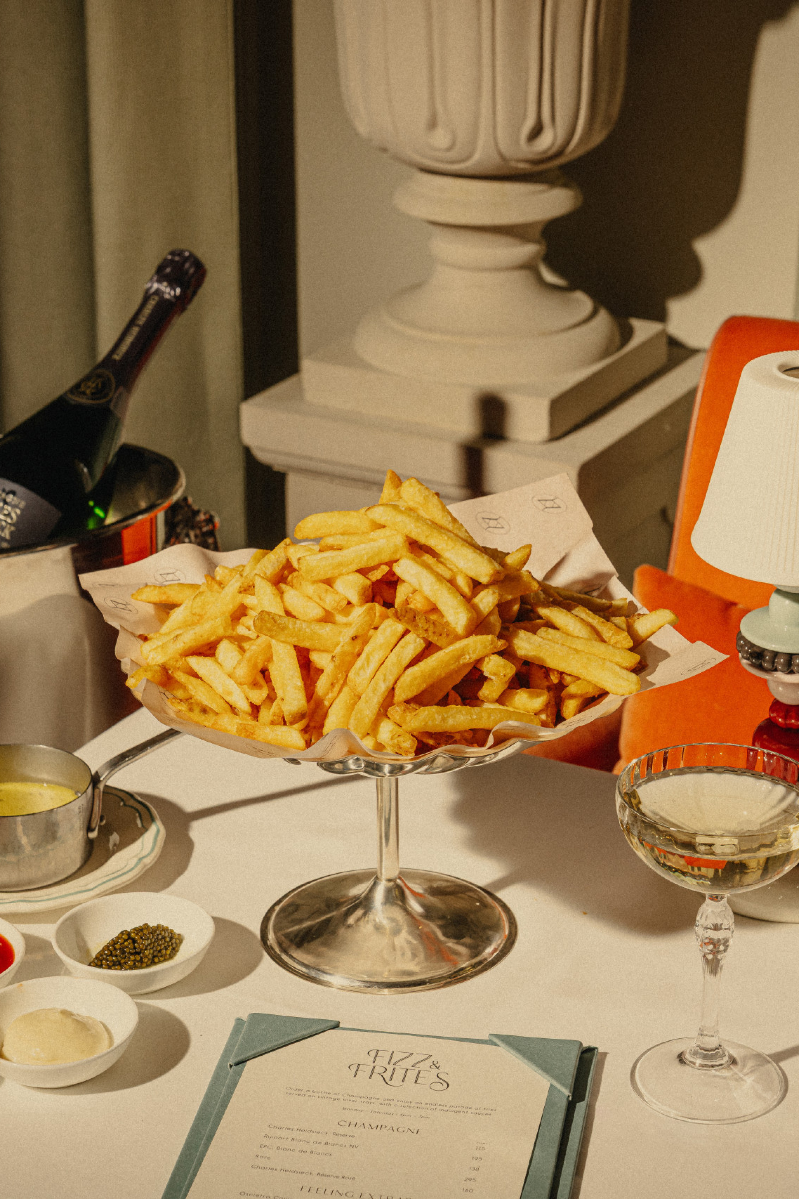 photo of table topped with plate of chips and two glasses of champagne