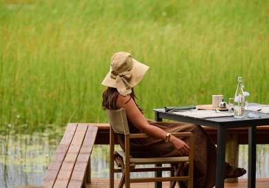 Woman sat at an outdoor table at sediba sa rona in botswana .
