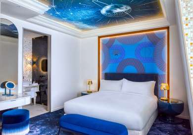 Kimpton bem budapest hotel bedroom with blue accents and king-sized bed.