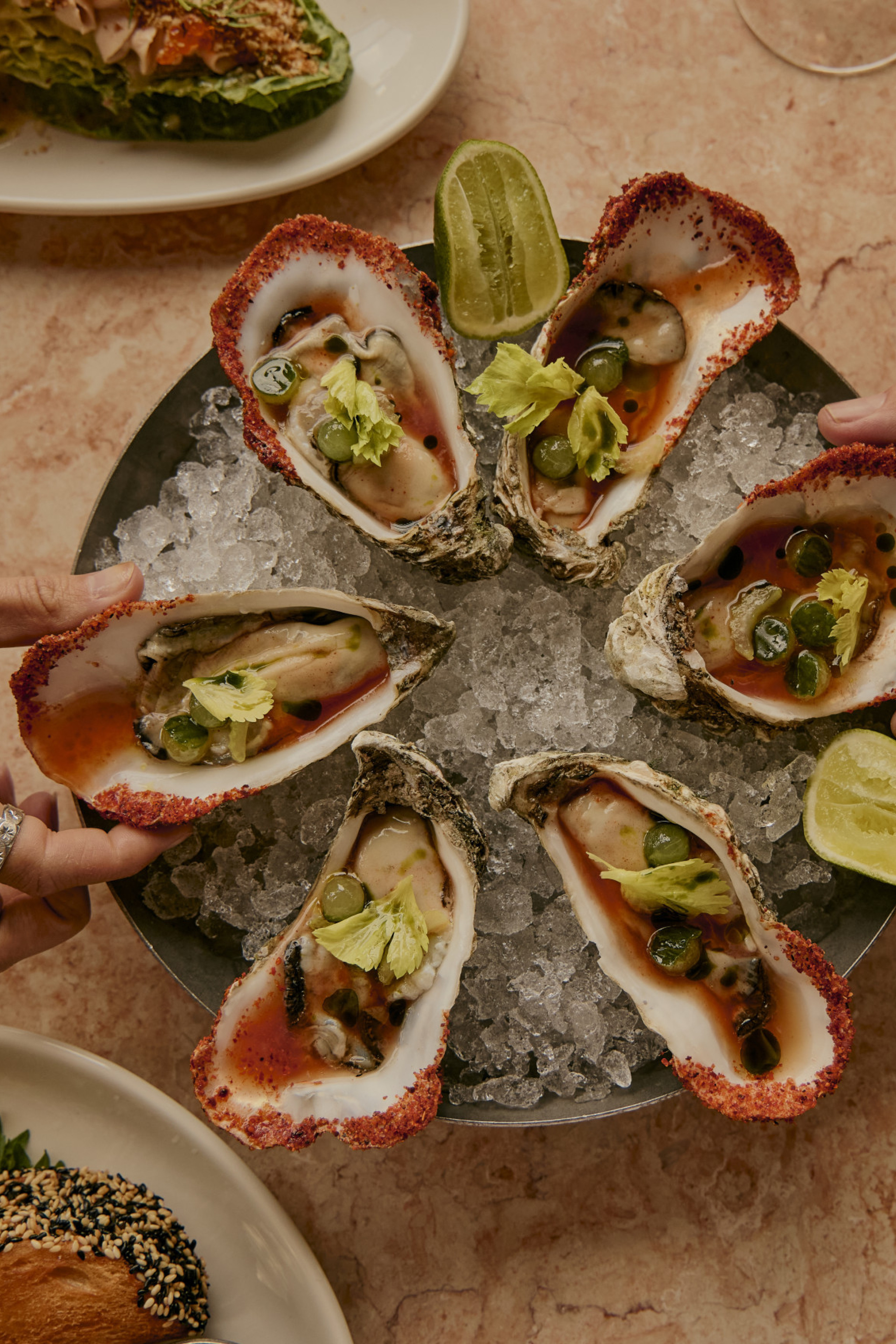 plate of oysters with side dishes and lime slices