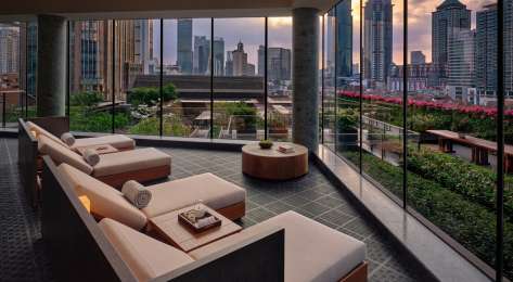 Hotel seating area with skyline views of shanghai .