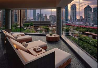 Hotel seating area with skyline views of shanghai .