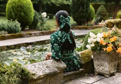 Model wearing green dress and matching bows .