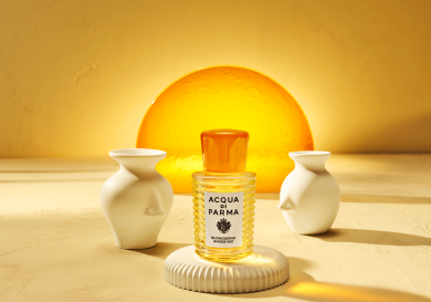 Bottle of yellow perfume stood between two small vases.