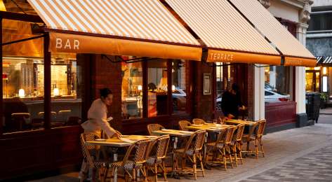 Photo of toum restaurant with striped awning .