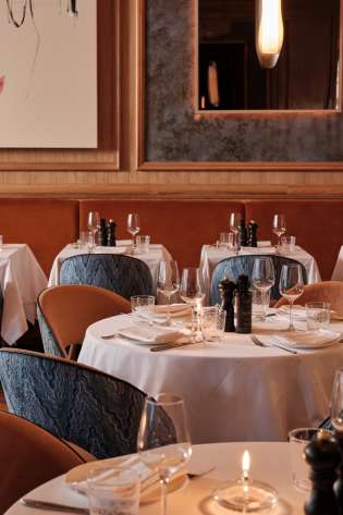 Round restaurant tables with blue chairs.