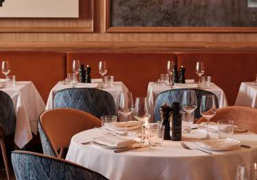 Round restaurant tables with blue chairs.