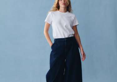 Model posing in baggy jeans and white T-shirt.