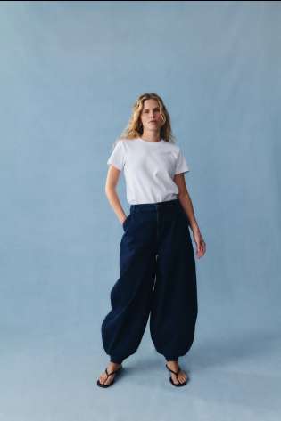 Model posing in baggy jeans and white T-shirt.