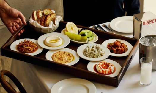 Small plates on wooden tray being served at kismet restaurant.