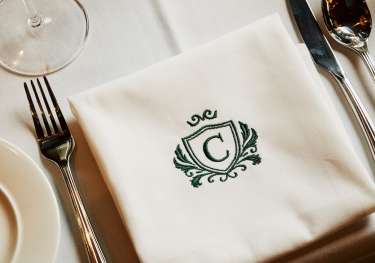 Napkin on table with green 'C' emblem.