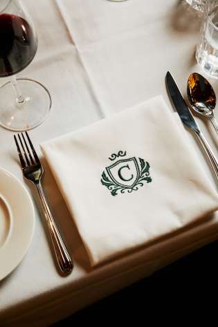 Napkin on table with green 'C' emblem.