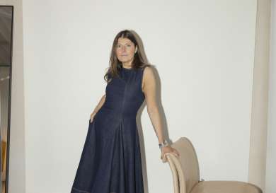Ginny seymour posing in denim dress and leather boots.