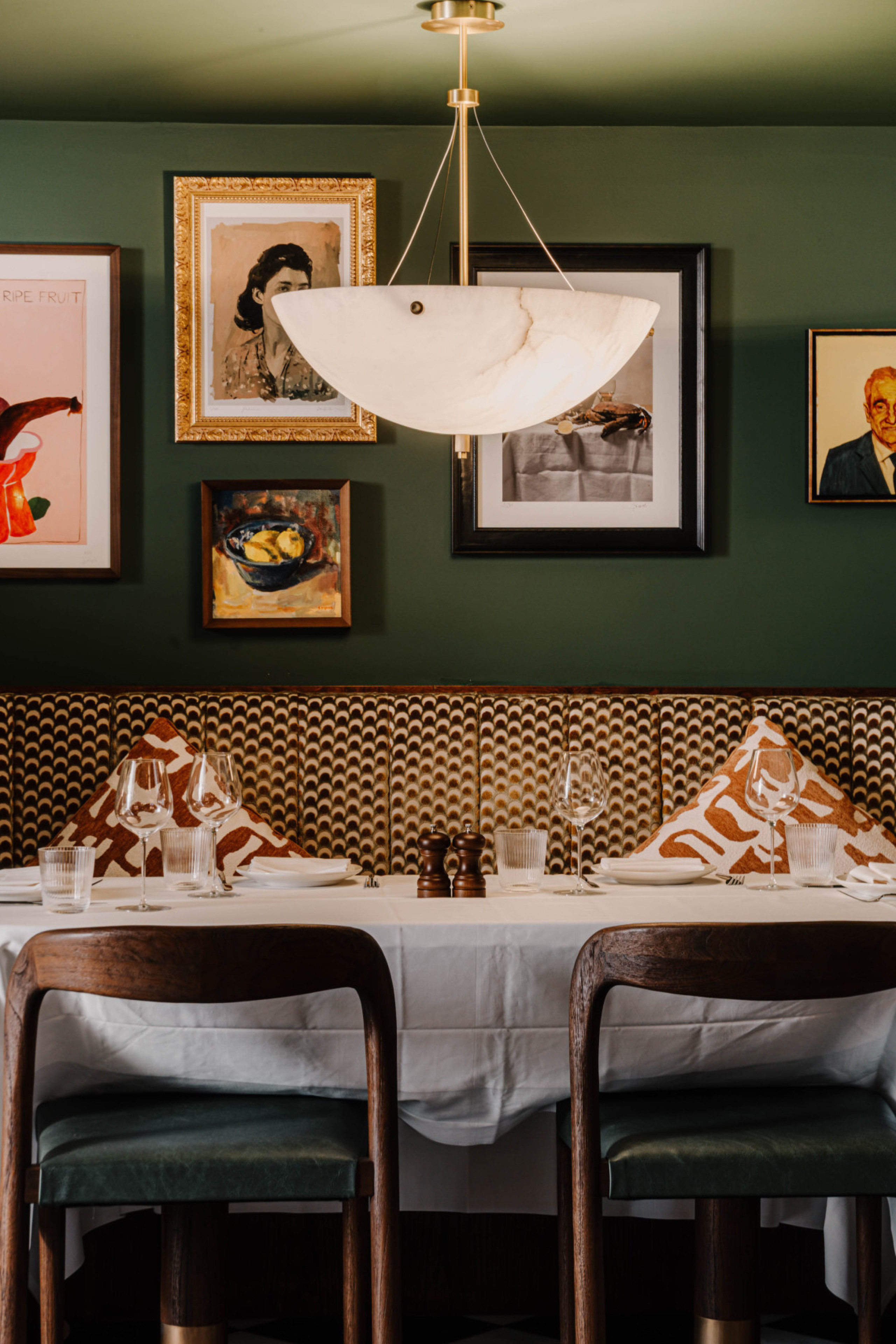 interiors at carmelinas restaurant with green walls and curved banquette seating
