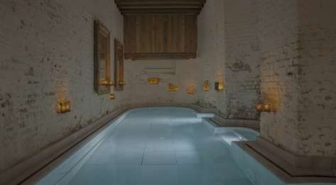 Bath inside spa with candles dotted about.