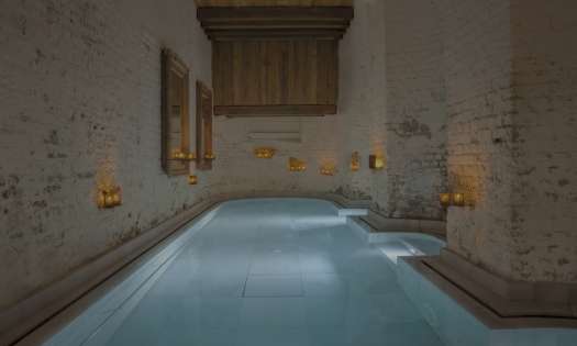 Bath inside spa with candles dotted about.