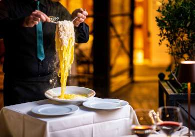 Person mixing fetuccine alfredo.