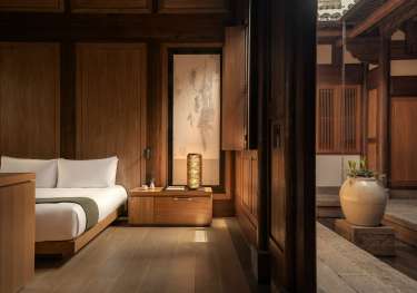 Hotel bedroom interiors with warm wood and neutral colours.