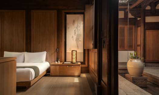 Hotel bedroom interiors with warm wood and neutral colours.