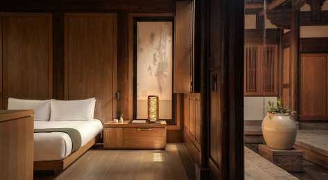 Hotel bedroom interiors with warm wood and neutral colours.