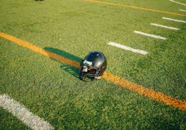 American football helmet on pitch .