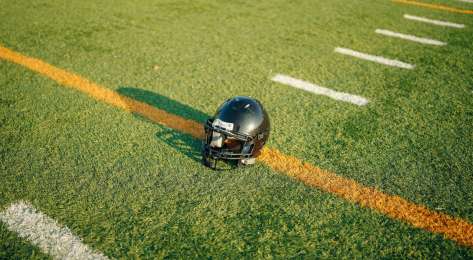 American football helmet on pitch .