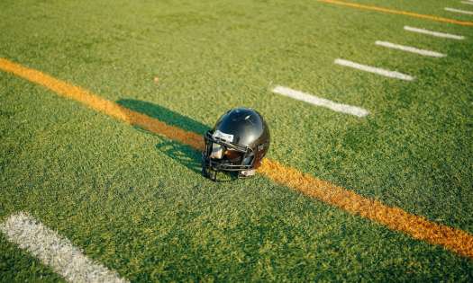 American football helmet on pitch .