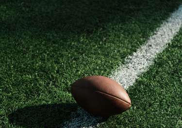 Single american football on pitch.