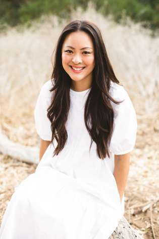 Amy lieu sitting on branch wearing white dress.