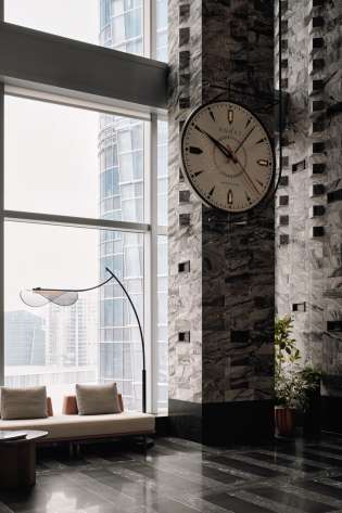 Hotel lobby area with giant clock on the wall .