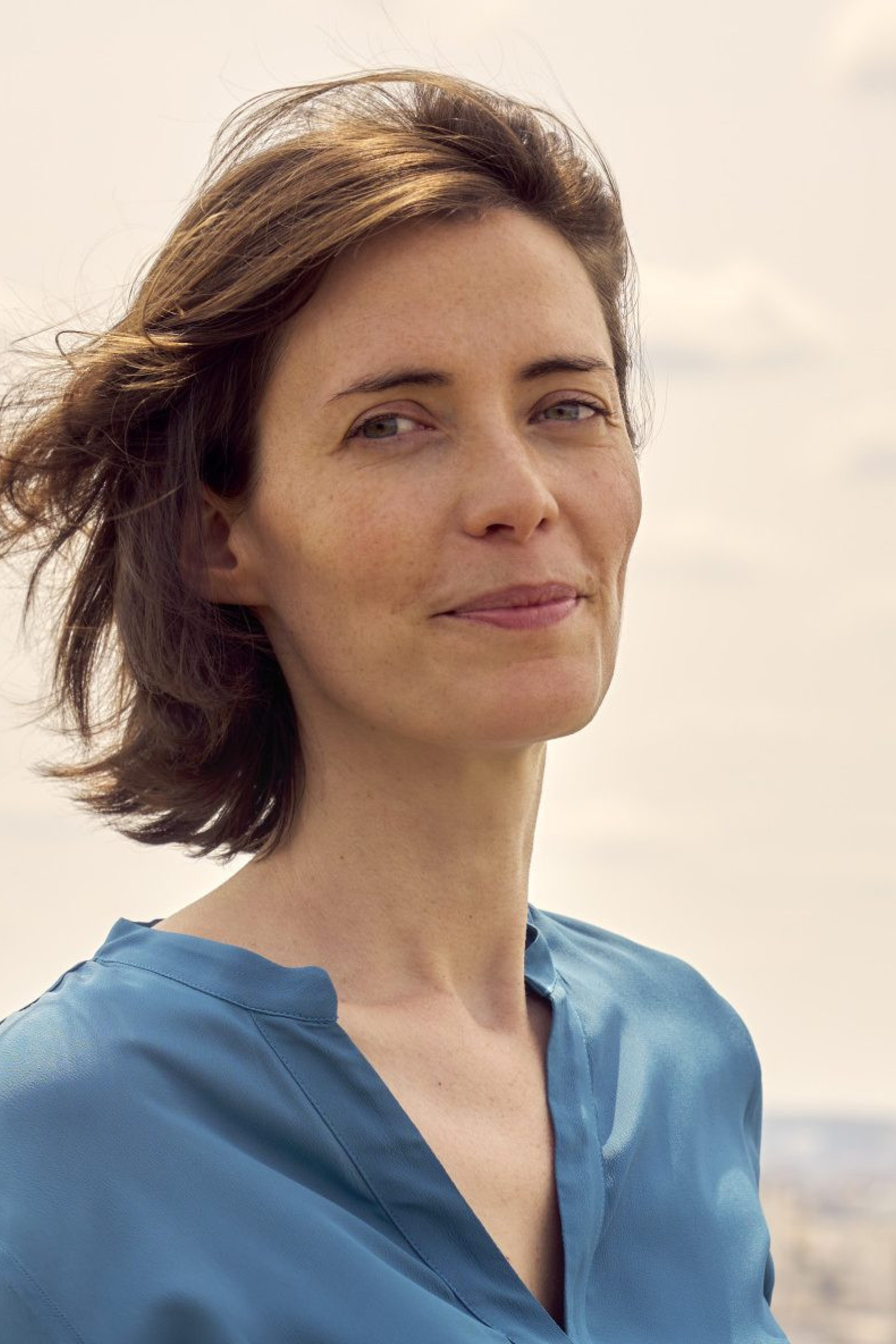 anne-laure pressat smiling in paris wearing blue blouse