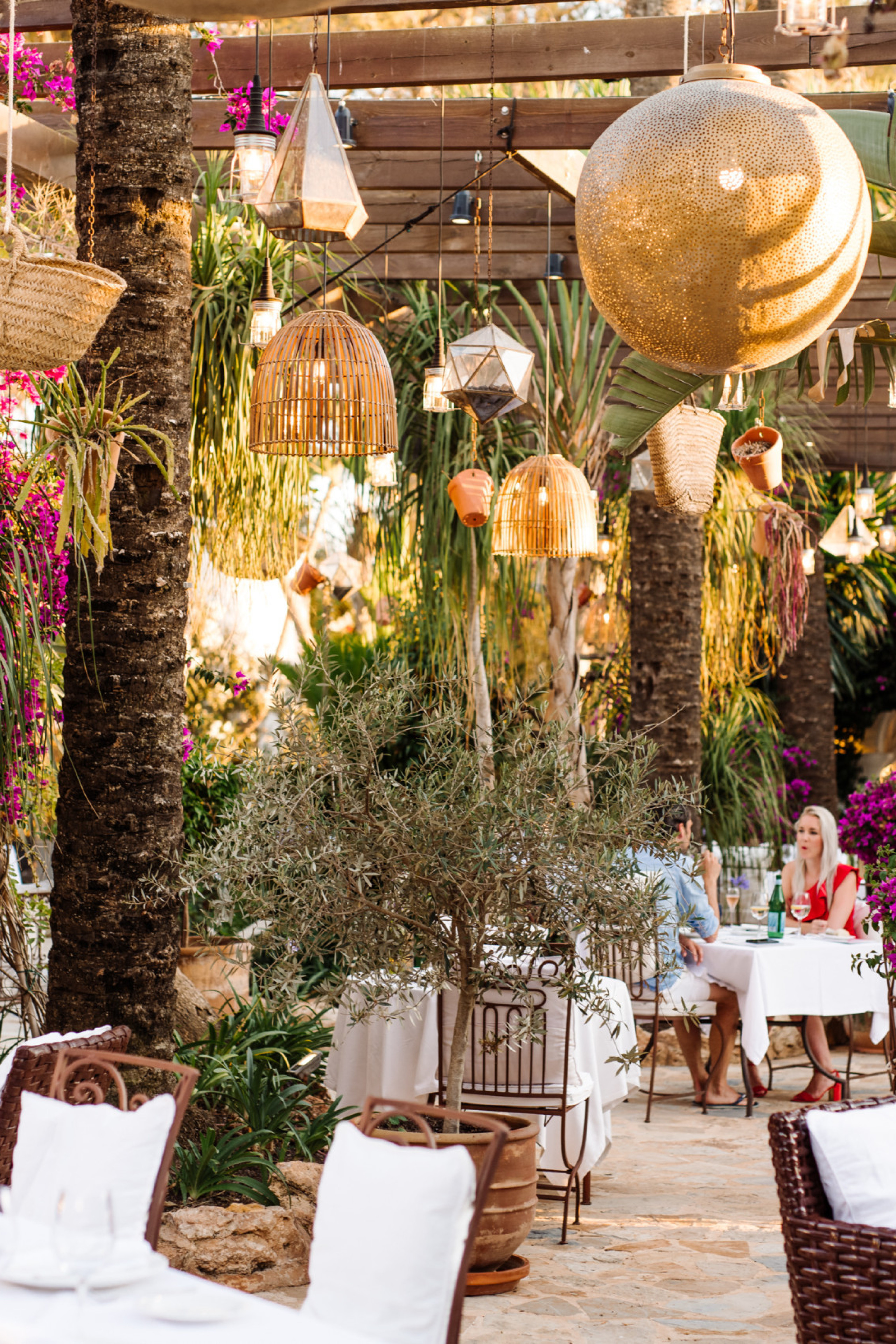 view of hotel restaurant with wicker chaires and hanging rattan lights