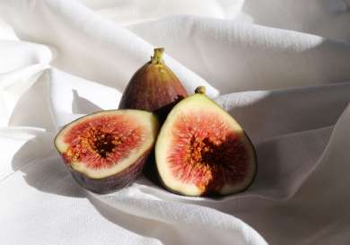 Sliced figs on white fabric .