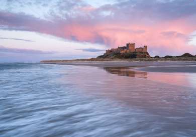 Bamburgh castle at sunset .