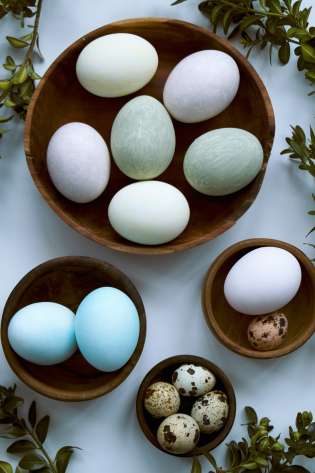 Blue eggs in brown wooden bowls .