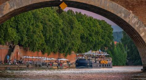 Boat going under bridge in toulouse.