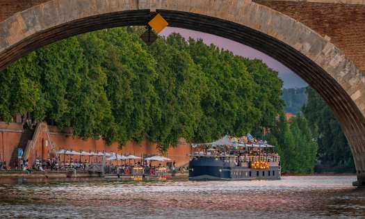 Boat going under bridge in toulouse.