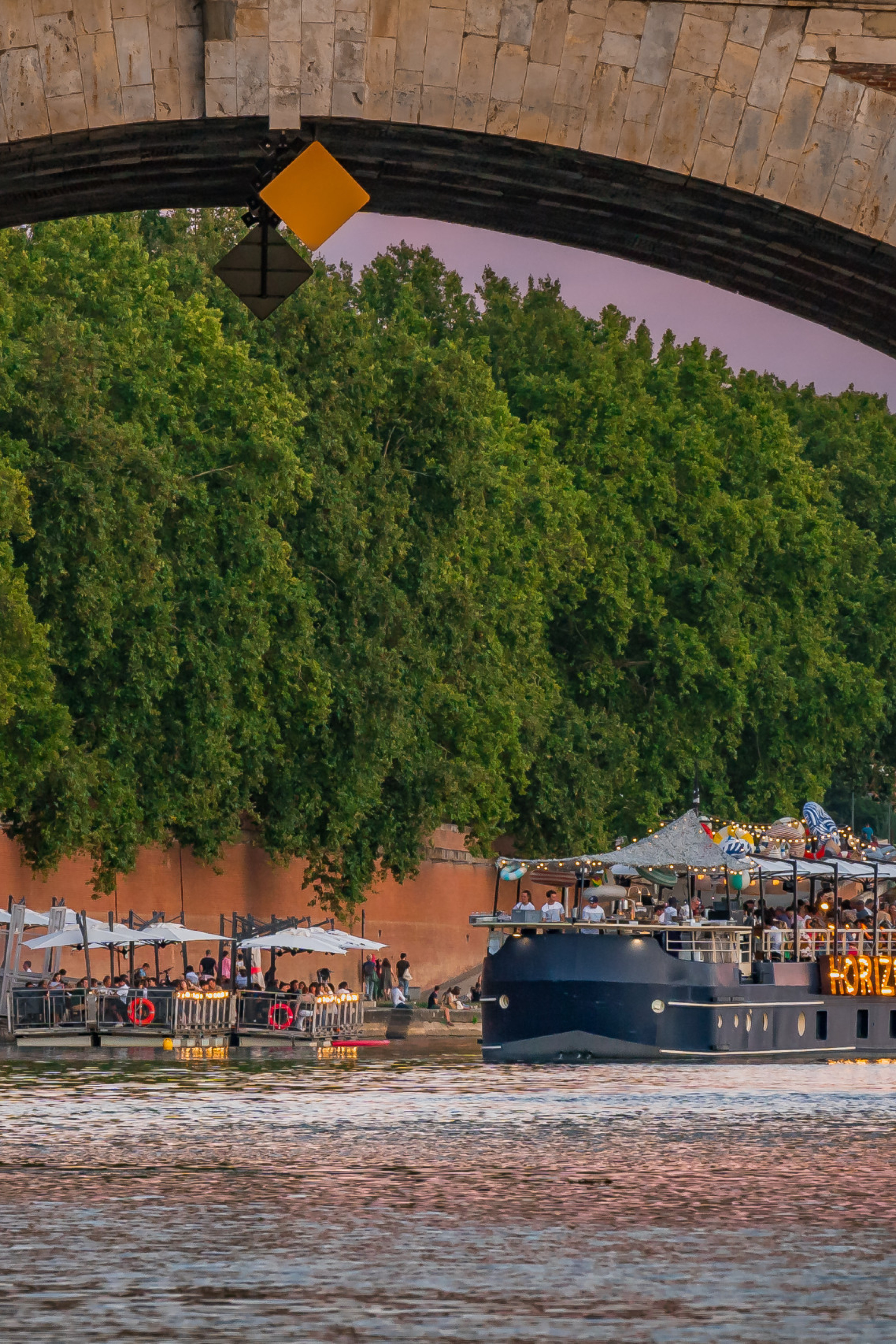 boat going under bridge in toulouse