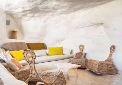 Hotel room with wicker chairs and sofa .