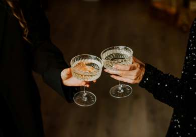 Two people clinking glasses of fizz .